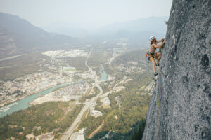 スコーミッシュの自然と街を見下ろす岩場で登るクライマー（ワーキングホリデー生活）