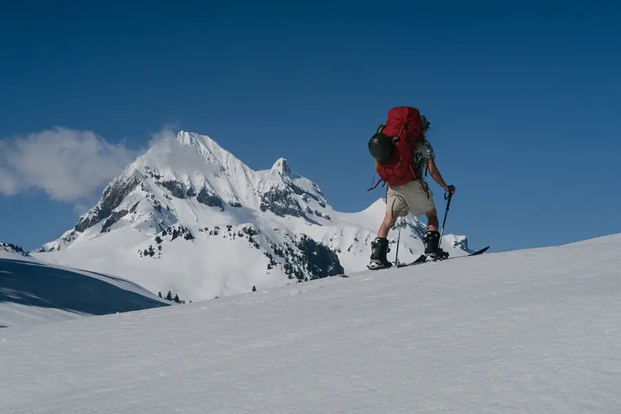 雪上を歩くスプリットボーダーとガリバルディ山